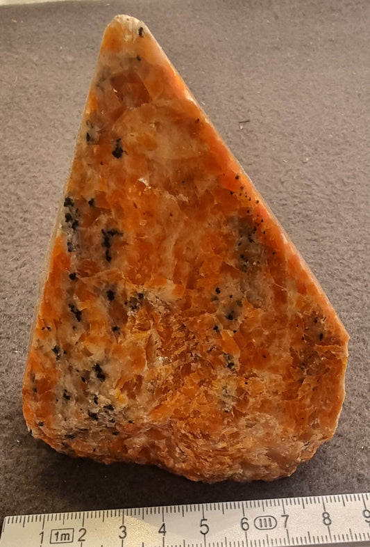 Oransje kalsitt med mørke mineralinneslutninger – polert freeform – 11 cm