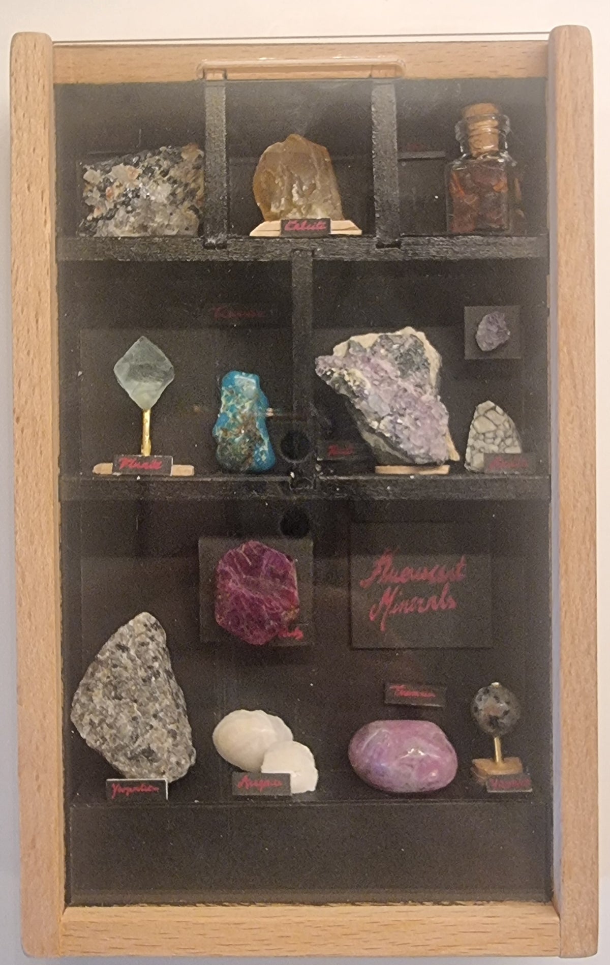 Fluorescerende mineralsamling i monter – med UV-belysning